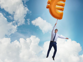 Businessman flying on euro sign inflatable balloon