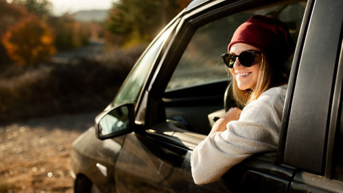 Woman driving in the car on the road trip