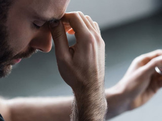 panoramic shot of depressed man with closed eyes holding glasses