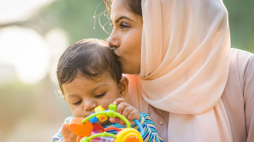 Arabic mom and her little toddler playing outdoors