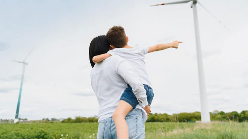 Alternative energy, wind farm and happy time with your family. Happy mother on the road with his son on vacation and escape to nature.