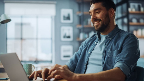 Handsome Caucasian Man Working on Laptop Computer while Sitting