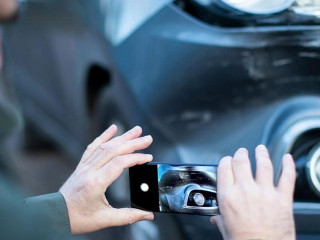 Male Driver Taking Photo Of Damaged Car After Accident For Insur