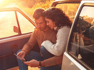 Beautiful couple on road trip, they are taking a break from driv