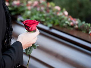 Frau auf Beerdigung mit Sarg