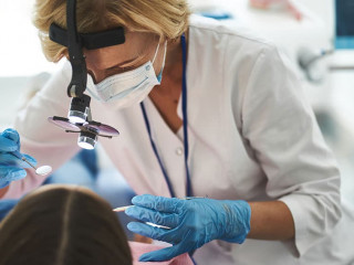 Woman is doing dental check-up for young girl