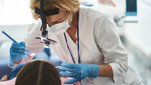 Woman is doing dental check-up for young girl