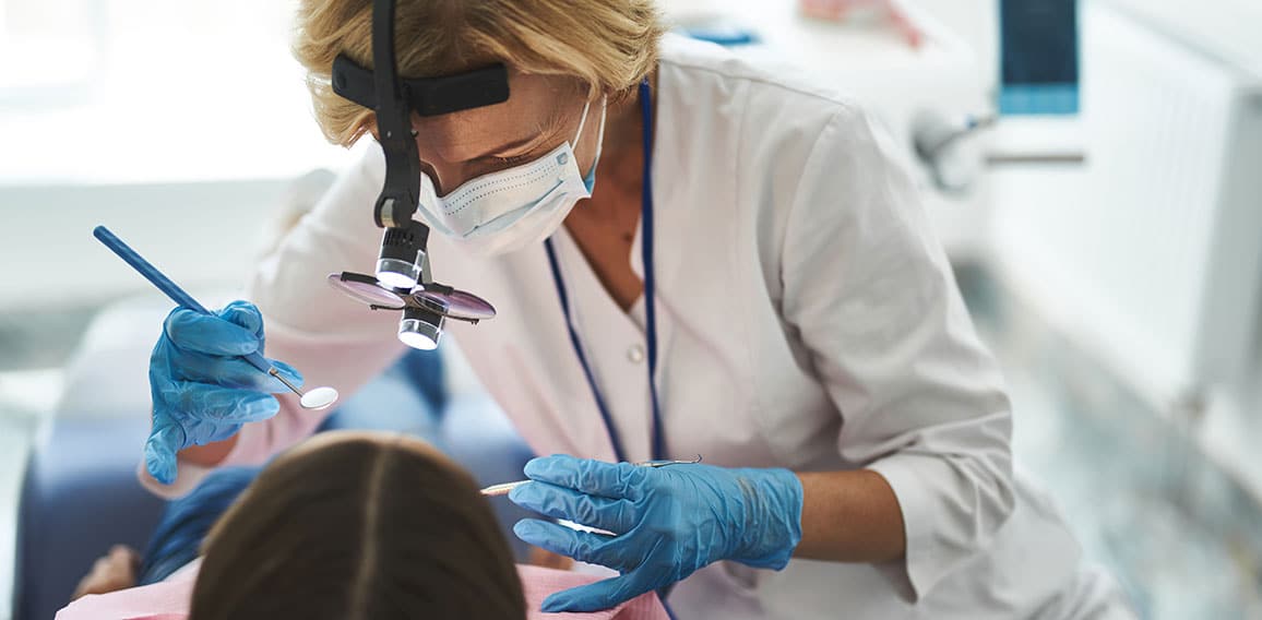 Woman is doing dental check-up for young girl