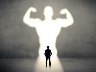 Businessman standing in front of a strong hero vision