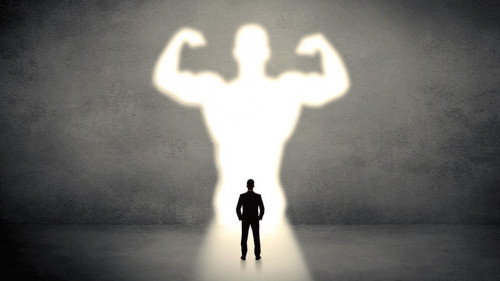 Businessman standing in front of a strong hero vision