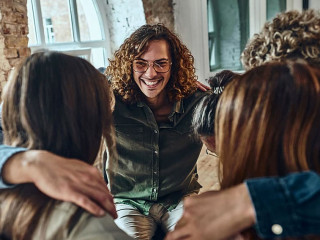 Teamwork embracing together in the workplace.