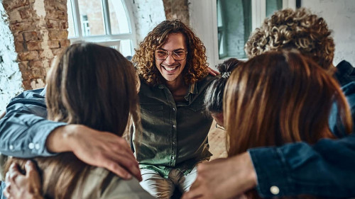 Teamwork embracing together in the workplace.