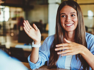 Happy successful hipster girl explaining information to male fri