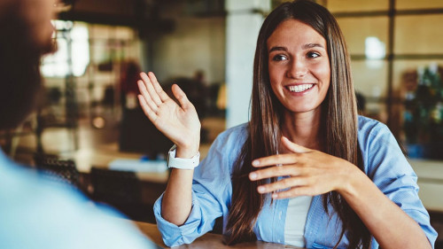 Happy successful hipster girl explaining information to male fri