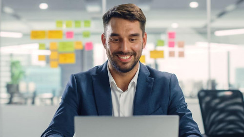 Busy Young Businessman Using Laptop Computer in Modern Office. M