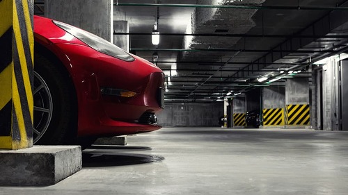 Dark scenic car park underground multilevel garage interior. Concrete cement column covered building basement floor electric vehicle parking lot zone. Modern urban city traffic infrastructure concept