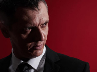 The evil boss. Portrait of an angry man in a business suit with red eyes with rage. Aggressive person
