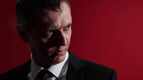 The evil boss. Portrait of an angry man in a business suit with red eyes with rage. Aggressive person
