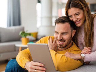 Couple in love using tablet computer at home and having fun