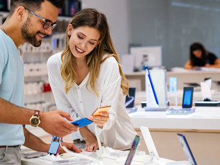 Shopping a new digital device. Happy couple buying a smartphone in store.