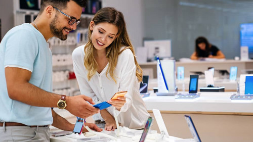 Shopping a new digital device. Happy couple buying a smartphone in store.