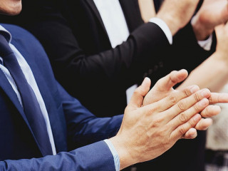 Group of businessmen are clapping their hands to congratulate th