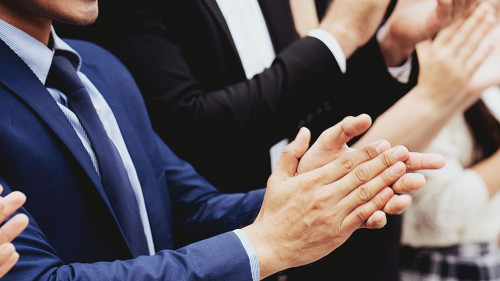 Group of businessmen are clapping their hands to congratulate th