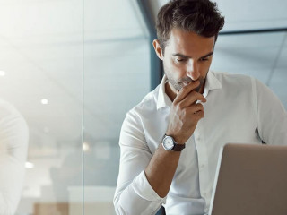 Carefully considering every option. Cropped shot of a handsome young businessman looking thoughtful while working on his laptop in the office.