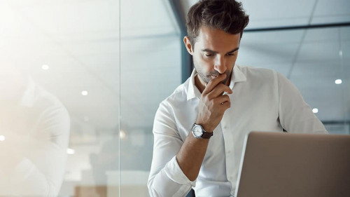 Carefully considering every option. Cropped shot of a handsome young businessman looking thoughtful while working on his laptop in the office.