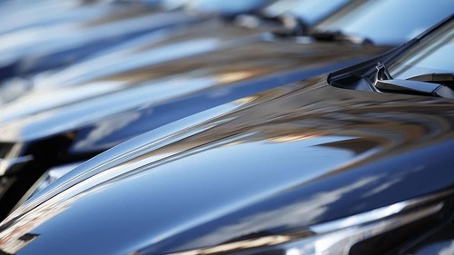The hood of the car. Row of cars on a parking lot. Black sedan c
