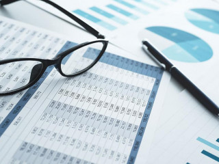 Many reports with graphs and figures. Glasses and pen. Financial