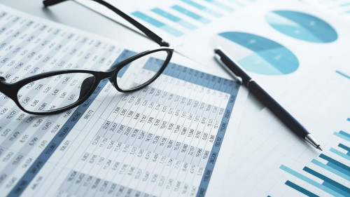 Many reports with graphs and figures. Glasses and pen. Financial