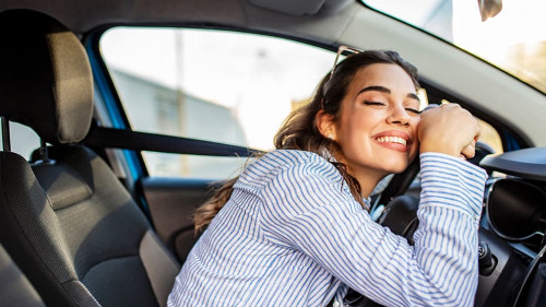 Young Woman Embracing Her New Car. Excited young woman and her n