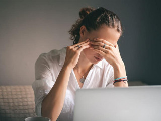 Young pretty woman in a white shirt sits at a table in front of