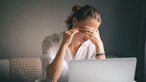 Young pretty woman in a white shirt sits at a table in front of