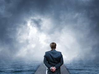 Man standing on pier looks at the sea