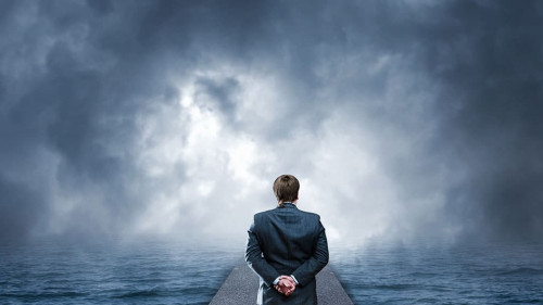 Man standing on pier looks at the sea