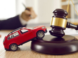 Little toy automobile on lawyer's table illustrating concept of car accident and lawsuit
