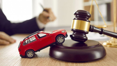 Little toy automobile on lawyer's table illustrating concept of car accident and lawsuit