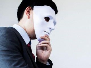 Business man giving dishonest handshake hiding in the mask - Business fraud and hypocrite agreement