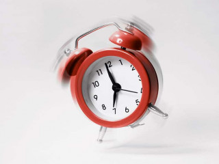 The blue morning alarm rings and jumps on a gray background.