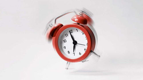 The blue morning alarm rings and jumps on a gray background.