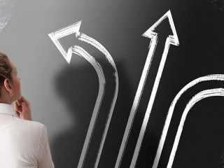 decision making concept with rear view of woman looking at chalkboard with arrows pointing in different directions