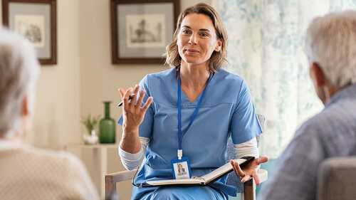 Psychologist having session with seniors at care facility centre