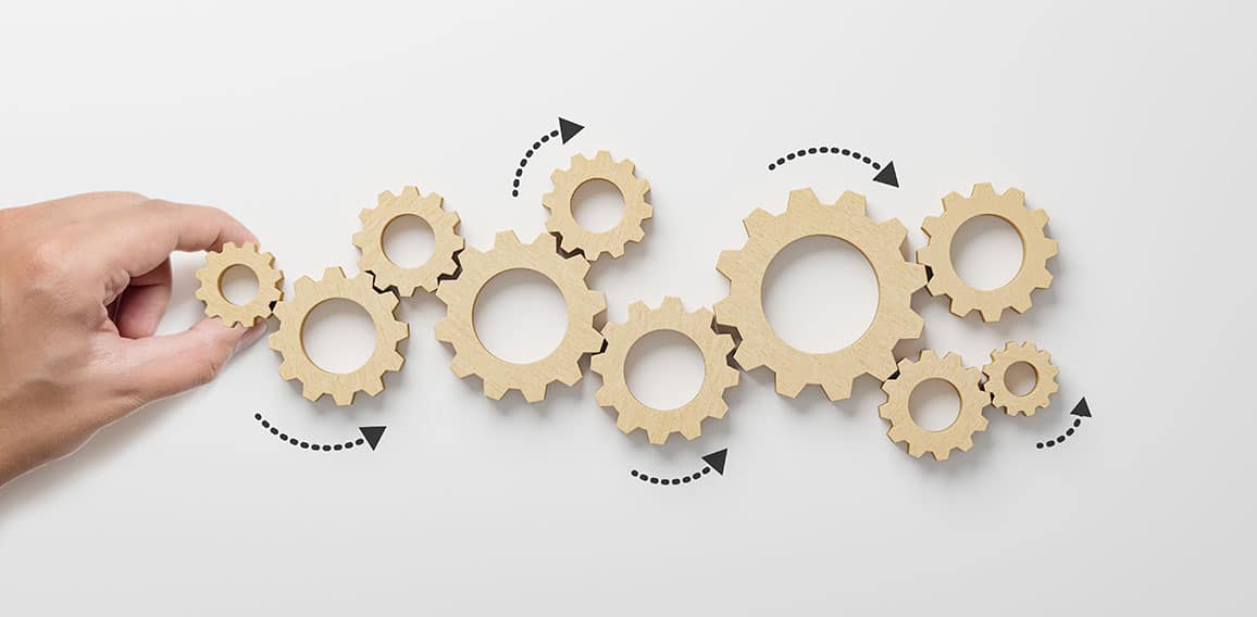 Business process and workflow automation with flowchart. Hand holding wooden cog flowing process management on white background
