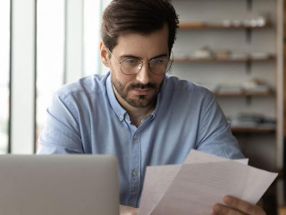 Focused businessman reviewing paper reports, received letter