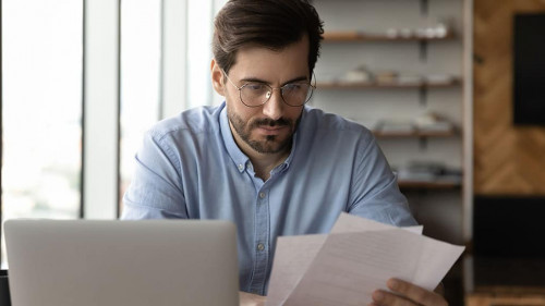 Focused businessman reviewing paper reports, received letter