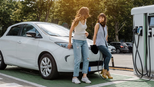 Two happy young beautiful women are talking to each other until