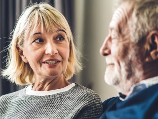 Senior couple relaxing and talking together sitting on sofa in l