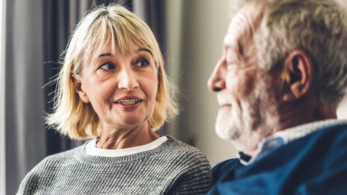 Senior couple relaxing and talking together sitting on sofa in l